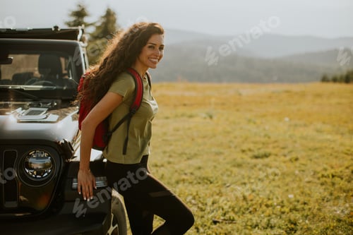 Preview: Young woman relaxing on a terrain vehicle hood at countryside