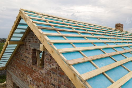 Preview: Aerial view of a brick house with wooden roof frame under construction
