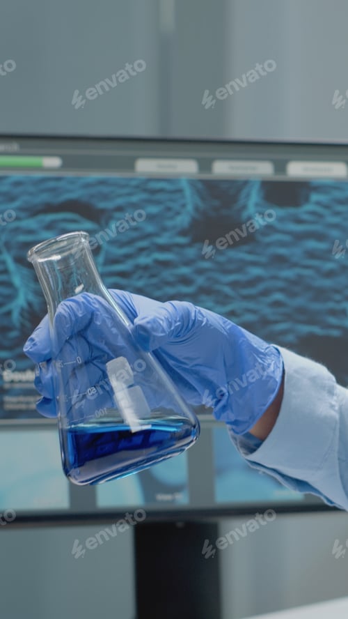Preview: Laboratory scientist analyzing chemical glass beaker