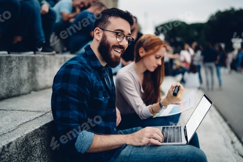 Preview: Happy Caucaisan programmer in spectacles using netbook for media browsing