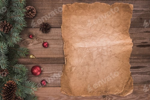Preview: top view of blank parchment, coniferous branches with pine cones and baubles, christmas background