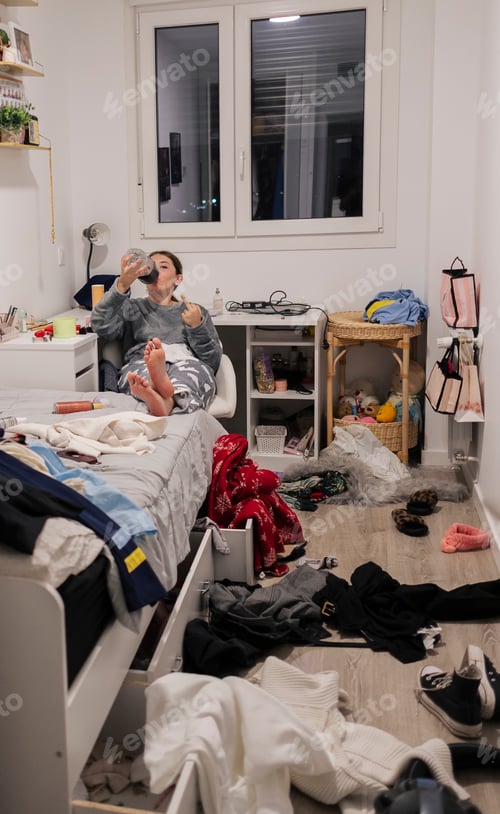 Preview: Teenage girl relaxing in messy untidy bedroom