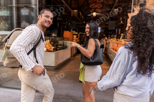 Preview: Friends smiling walking together shopping in market