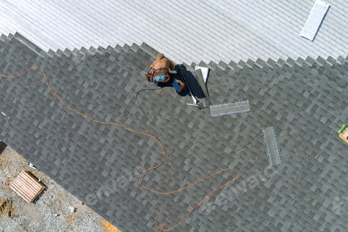 Preview: A asphalt shingles installation on the roof roofer is nailing asphalt shingles to roofing constructi