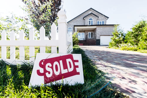 Preview: beautiful new house with sign sold standing on grass