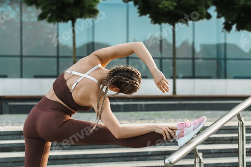 Preview: Sportive woman is stretching during fitness workout outdoors