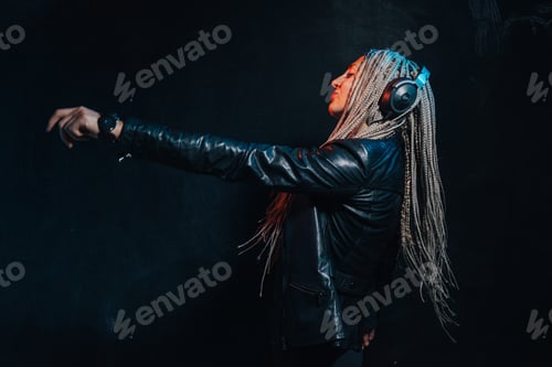 Preview: A beautiful girl listens to music with headphones on a black background