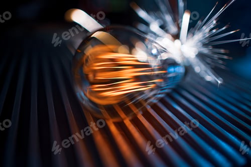 Preview: The incandescent lamp does not shine brightly and sparks fall on the metal surface in a dark room