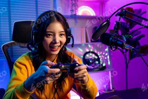 Preview: Asian young beautiful esport woman playing games in neon room at home.