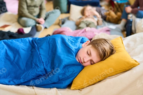 Preview: Peaceful schoolboy napping on sleeping place under blue blanket