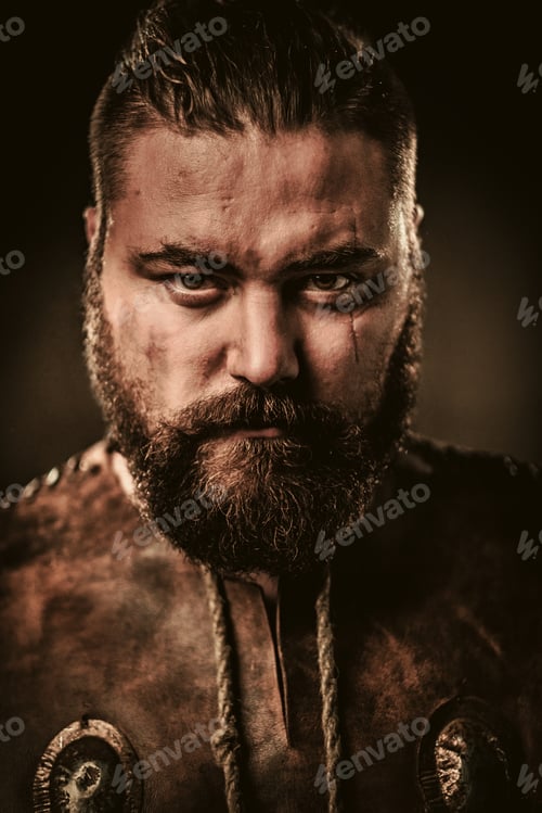 Preview: Angry viking in a traditional warrior clothes, posing on a dark background.