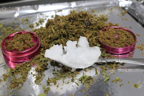 Preview: Closeup of a spoon full of coconut oil to be infused with decarboxylated cannabis flowers and leaves