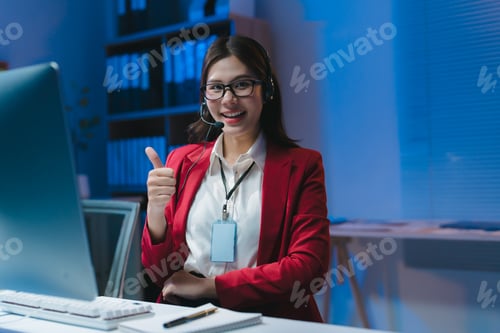Preview: Asian businesswoman showing thumbs up working overtime in office at night