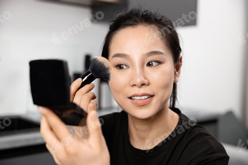 Preview: Woman Applying Makeup with Brush in Modern Room
