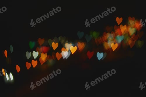 Preview: Multicolored bokeh of heart-shaped lights on a black background
