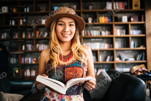 Preview: Young woman reading book and fresh cup of coffee on the table