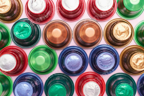 Preview: Multi-colored capsules for coffee machine close-up, top view.
