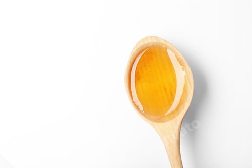 Preview: Spoon with delicious honey on white background, top view