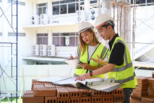 Preview: Civil engineer team discussing, planning development details together at construction site.