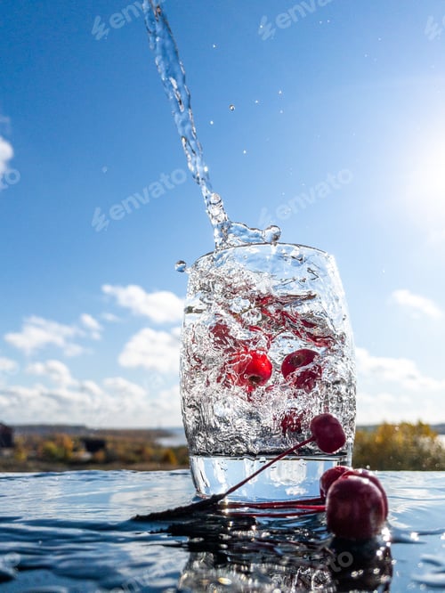 Preview: Red berries in a glass with pouring water