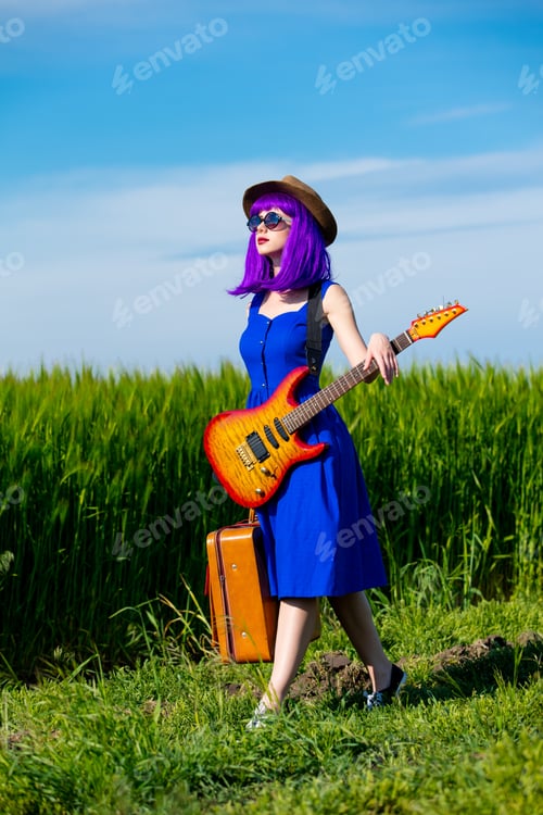 Preview: young woman with suitcase and guitar