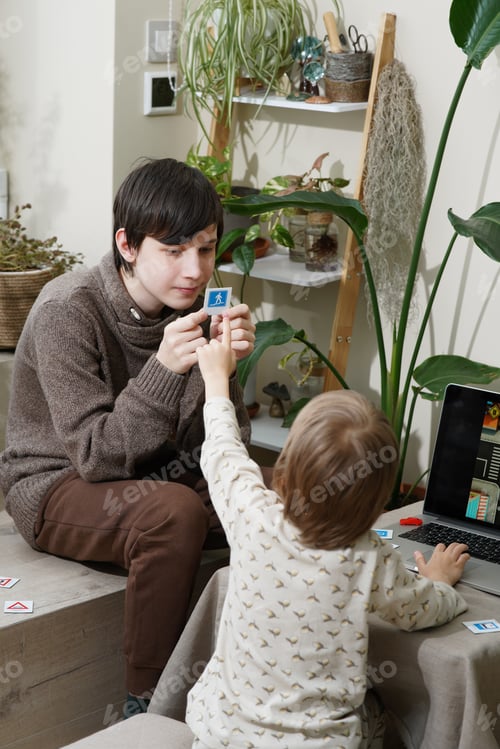 Preview: Online education. Boys learning traffic rules using cards and game educational application on laptop
