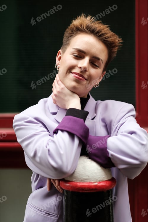 Preview: Short-hair young woman posing with close eyes in front of red hair.