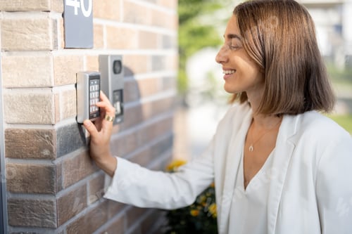 Preview: Woman entering code on a keyboard to access a door