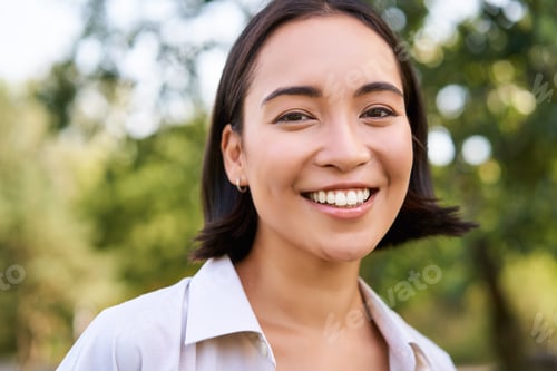 Preview: Close up face of asian happy girl, smiling and looking at camera carefree, walking in park