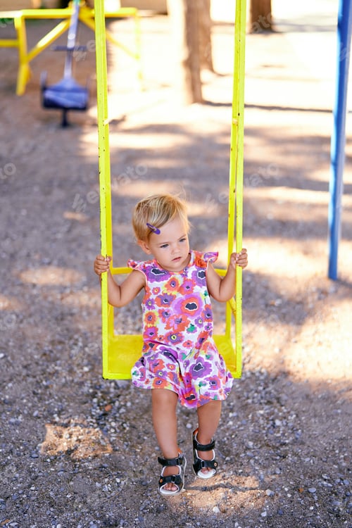 Preview: Little girl on a swing in the playground