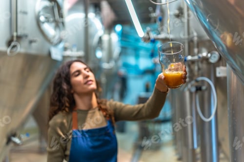 Preview: Woman brewer pouring craft beer during quality check