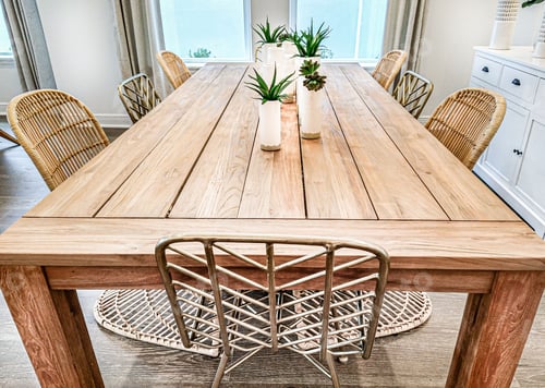 Preview: Beautiful wooden dining table with plant pots on it and wicker chairs