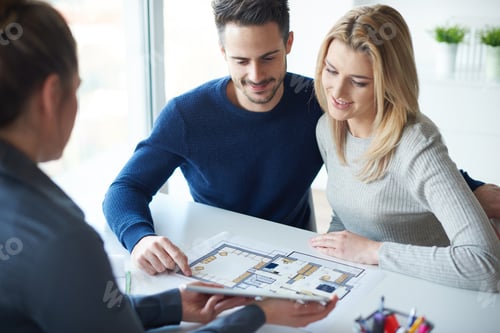 Preview: Saleswoman showing paperwork to couple