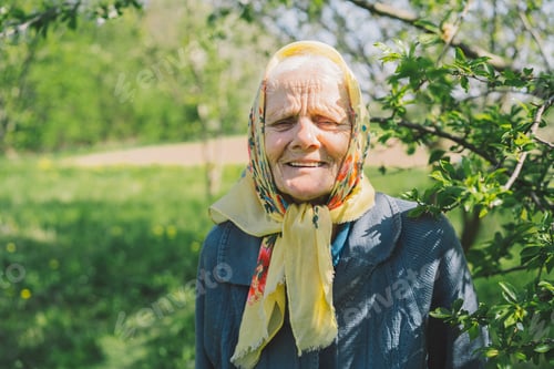 Preview: Portrait of an old happy woman in a yellow headscarf.
