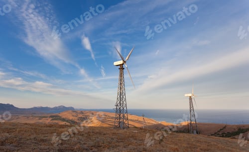 Preview: Wind turbine generating electricity in mountains at sunset
