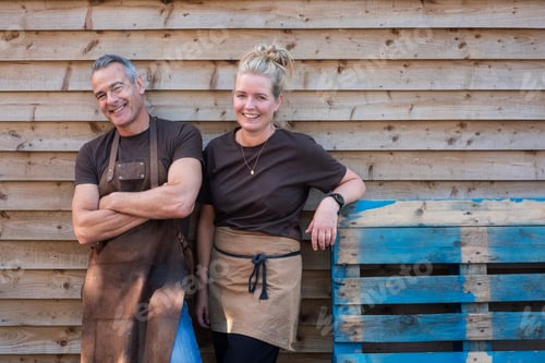 Preview: Man and woman in aprons, colleagues taking a break from work, laughing
