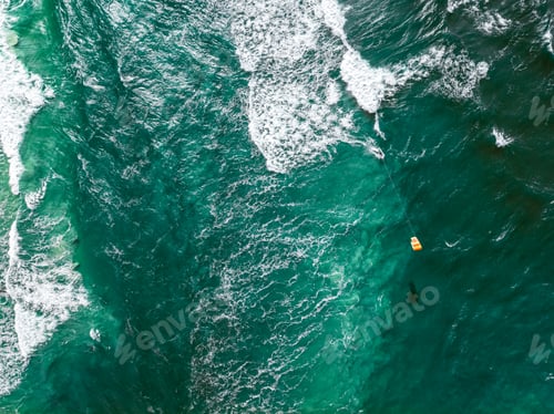 Preview: Aerial view of kitesurfer riding on waves at Baltic Sea.