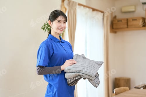 Preview: Asian caregiver doing laundry during home visit care