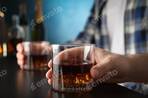 Preview: Men holding glasses of whiskey at the bar, space for text