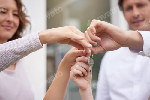 Preview: Closeup hands of happy married couple holding up house keys. Man and woman holding keys to new hous