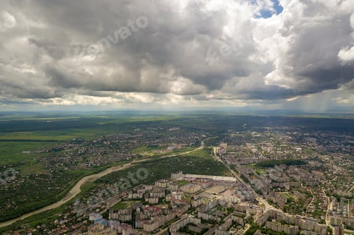 Preview: Aerial view of town or city with rows of buildings and curvy streets in summer. Urban landscape from