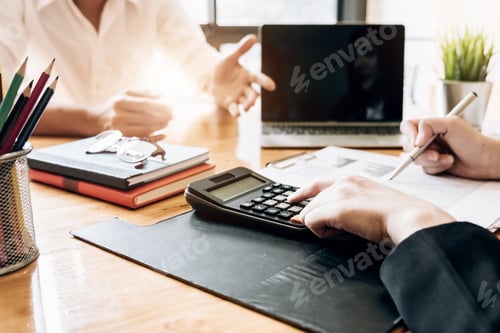 Preview: Close up Businessman and partner using calculator and laptop for calaulating finance, tax