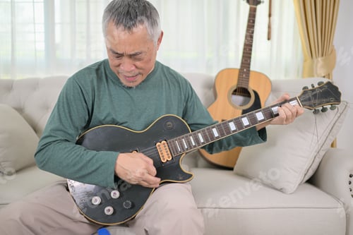 Preview: Senior man a veteran guitarist plays the old electric guitar at home