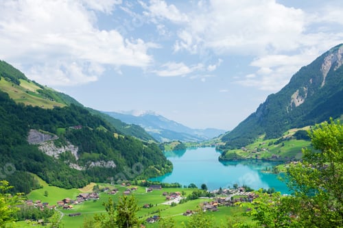 Preview: Panoramic view of lake, countryside, green alpine meadows and mountains