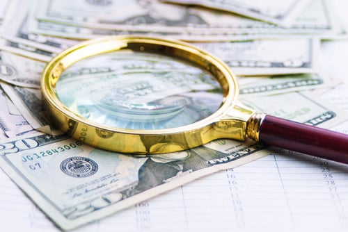 Preview: the magnifying glass is on top of a wad of dollars