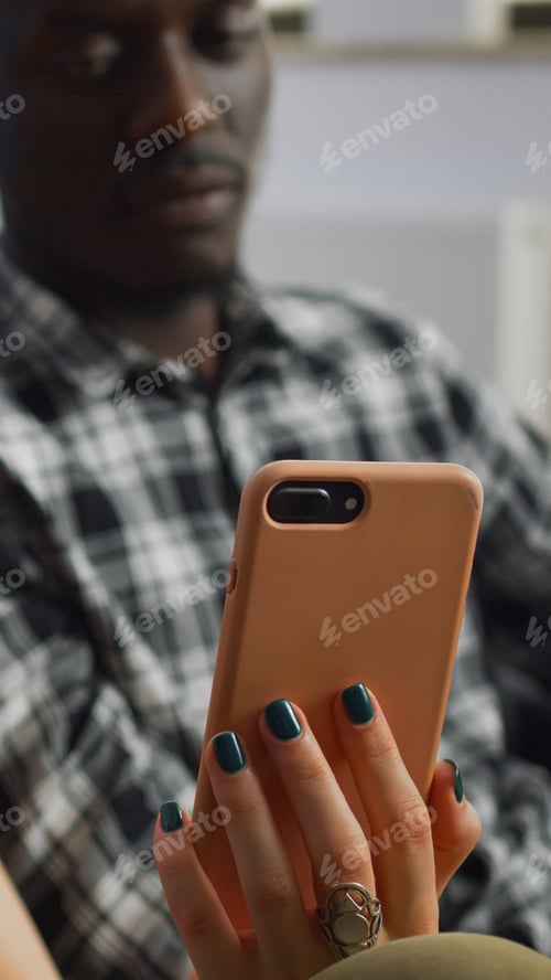 Preview: Close up of interracial couple looking at smartphone