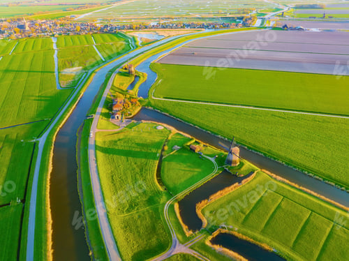 Preview: An aerial view of the windmill. Canals with water for agriculture. Fields and meadows.