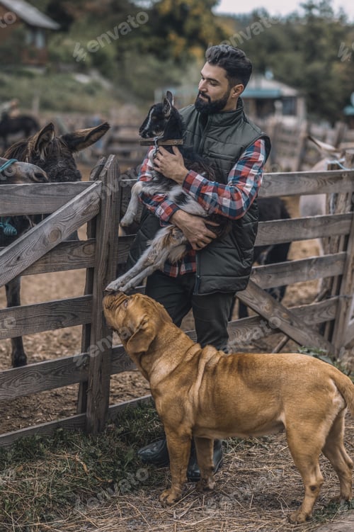 Preview: A happy farmer holding a cute goatling