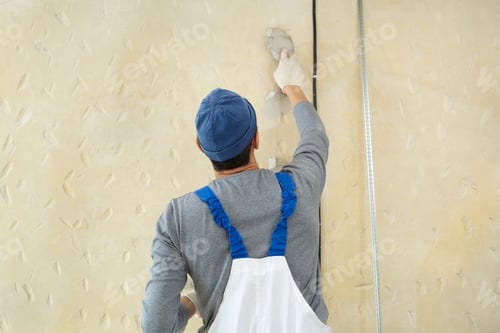 Preview: A hand with a spatula. Workers put putty on the wall with a spatula. Aligns wall.