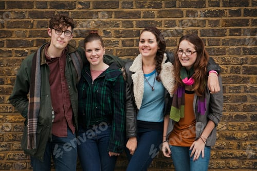 Preview: Four friends sharing a laugh against a brick wall backdrop.